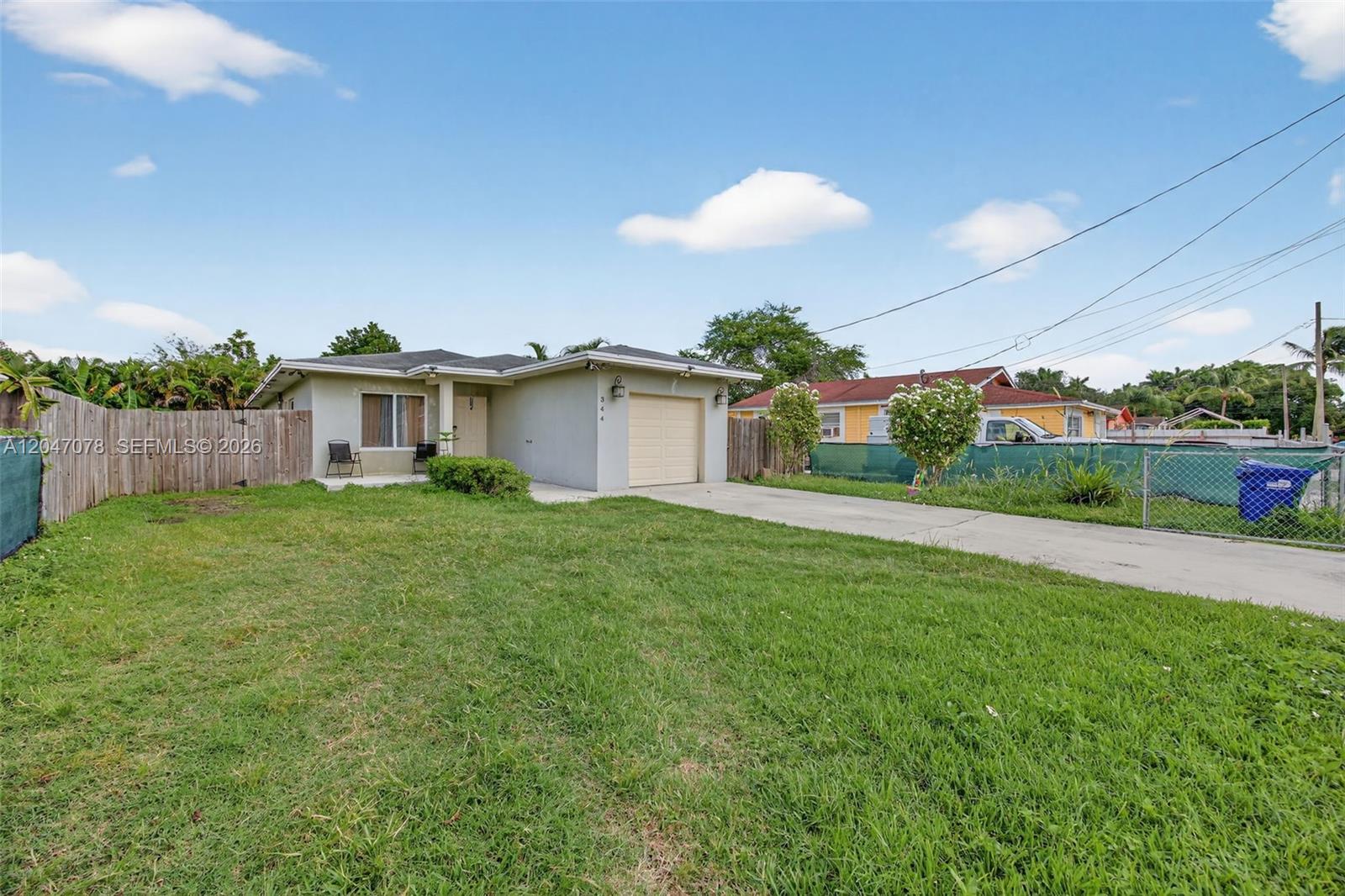 A single-story house with a beige exterior, a one-car garage, and a large front lawn — 344 SW 3rd St, Florida City FL 33034, FLORIDA CITY, FL