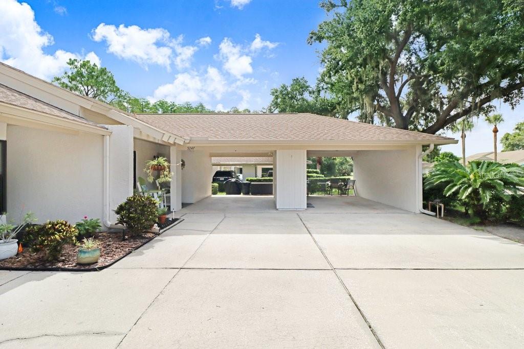 A concrete driveway leads to a covered carport attached to the side of a house — 9247 GOLF VIEW DRIVE UNIT 9247, NEW PORT RICHEY, FL