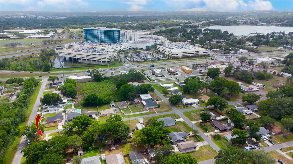An aerial view shows a residential neighborhood with a red arrow pointing to a house — 7716 E COMANCHE AVENUE, TAMPA, FL