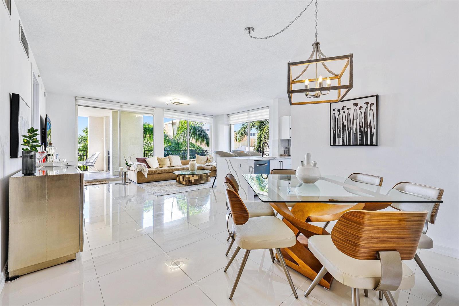 A bright open-concept living and dining area features white tile floors and floor-to-ceiling windows — 550 Okeechobee Boulevard # 422, West Palm Beach FL 33401, WEST PALM BEACH, FL