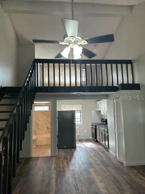 A view of a living area with a staircase, loft, and an open kitchen — 2122 BRADFORD STREET UNIT 521, CLEARWATER, FL