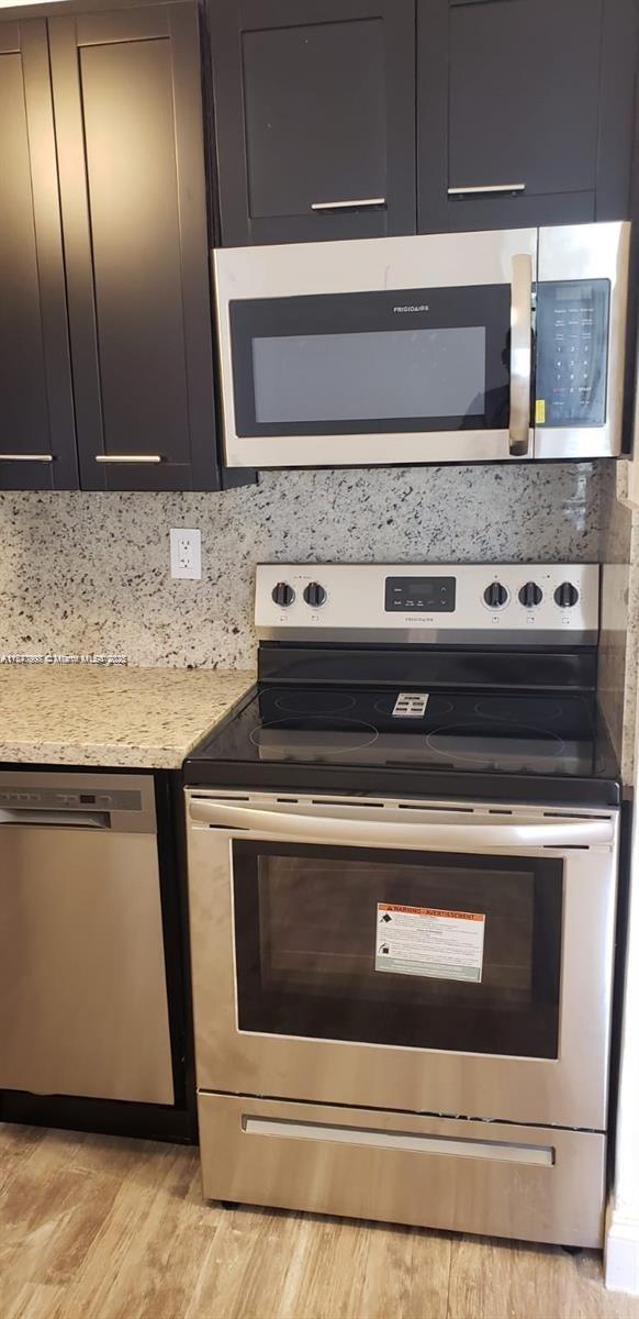 A kitchen features dark cabinets, stainless steel appliances, and speckled granite countertops — 9709 Hammocks Blvd # 202, Miami FL 33196, MIAMI, FL
