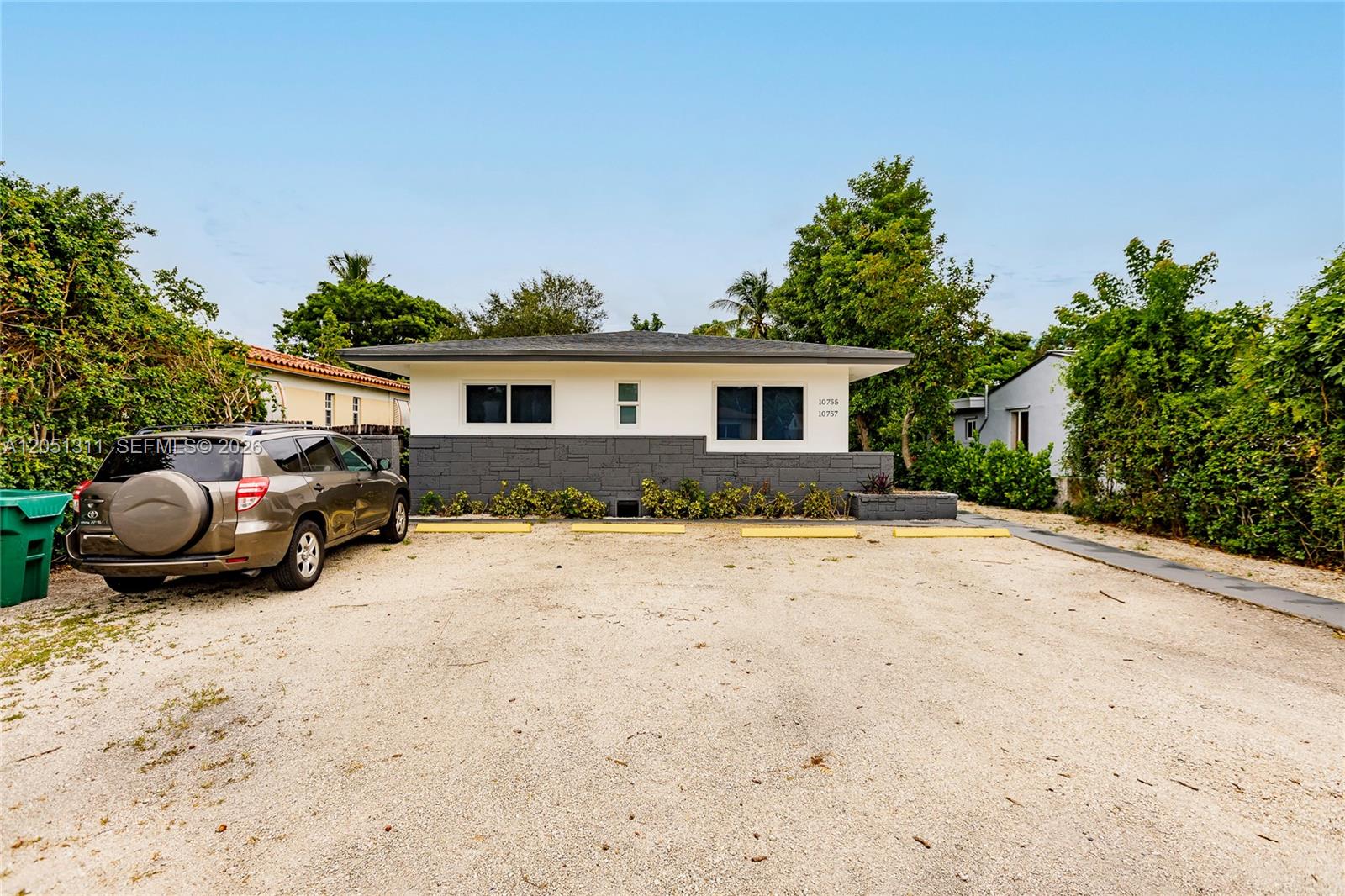 A single-story building with a gravel parking lot and a dark stone facade — 10757 NE 2 Ct # 0, Miami FL 33161, MIAMI, FL