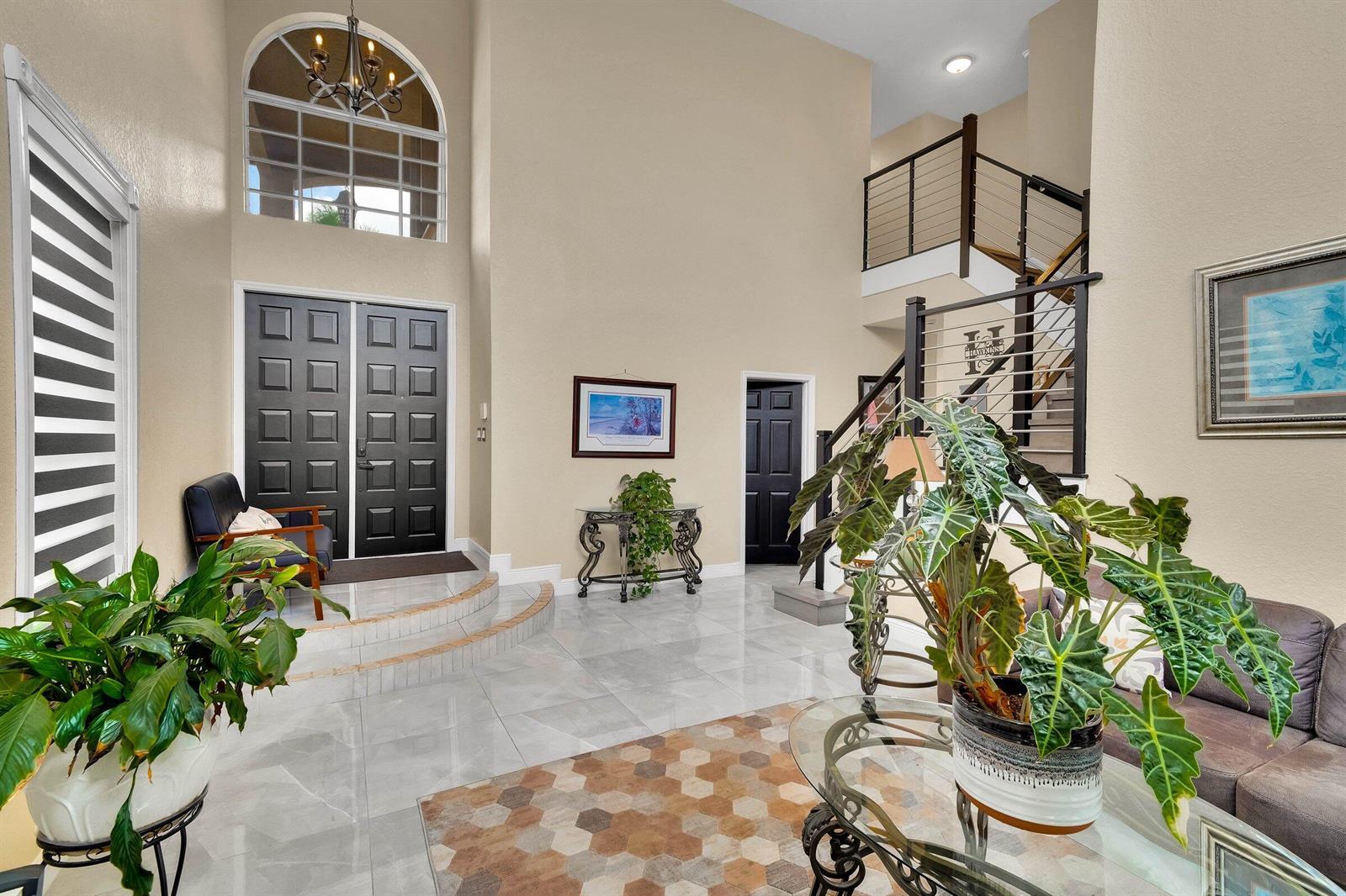 A spacious foyer features high ceilings, a grand staircase, tiled floors, and double front doors — 16254 SW 18th Place, Miramar FL 33027, MIRAMAR, FL