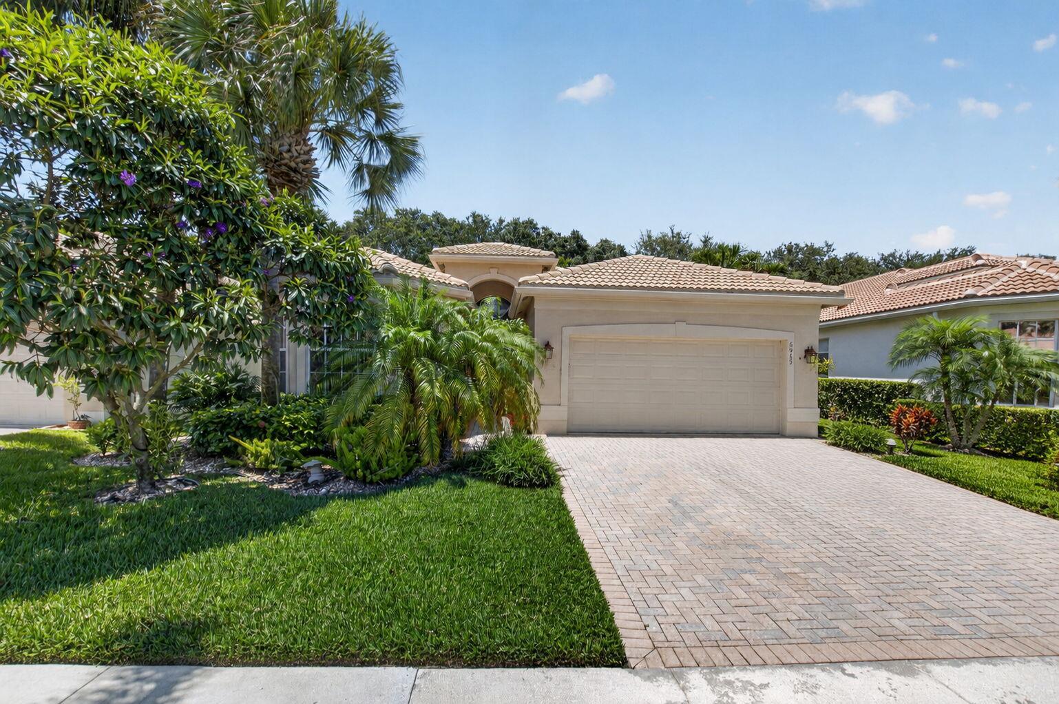A single-story house with a beige stucco exterior, tile roof, and a paved driveway — 6959 Imperial Beach Circle, Delray Beach FL 33446, DELRAY BEACH, FL