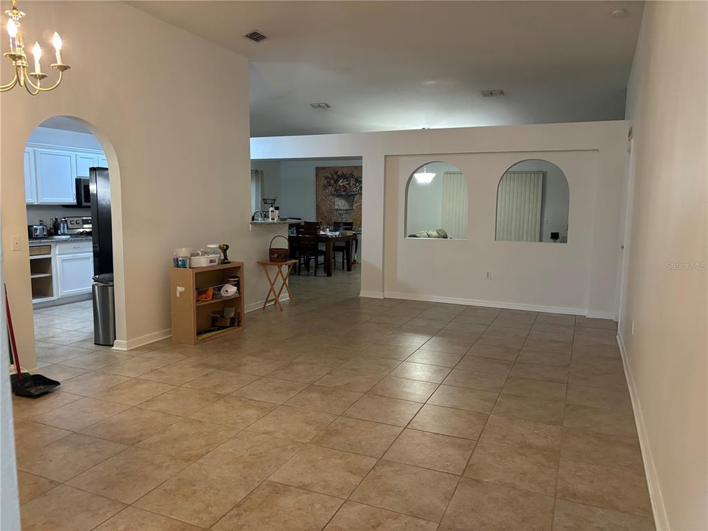A tiled living area features arched wall cutouts and an adjacent kitchen with white cabinets — 304 MARION OAKS TRAIL, OCALA, FL