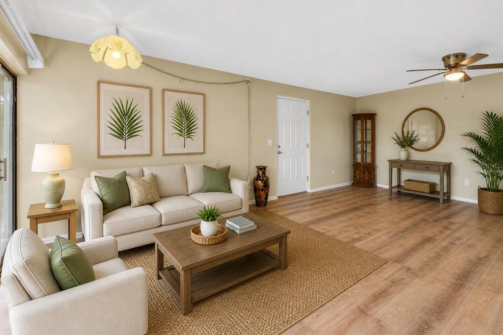 A living room features a beige sofa, a coffee table, and wood-look flooring — 1515 FORREST NELSON BOULEVARD UNIT N104, PORT CHARLOTTE, FL