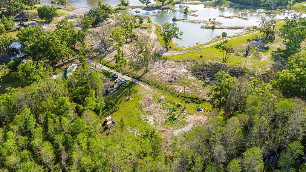 An aerial view shows a rural property with a small house, outbuildings, and several ponds — 4436 JOY DRIVE, LAND O LAKES, FL