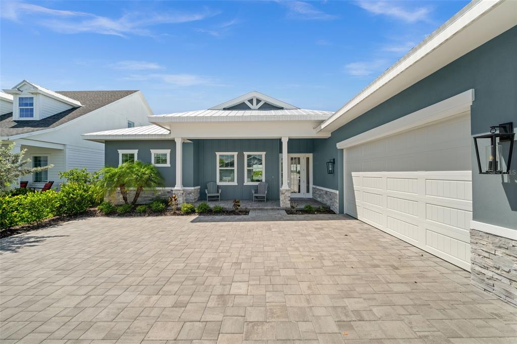 A blue house with a stone base, white trim, and a paved driveway — 42231 LAKE TIMBER DRIVE, PUNTA GORDA, FL
