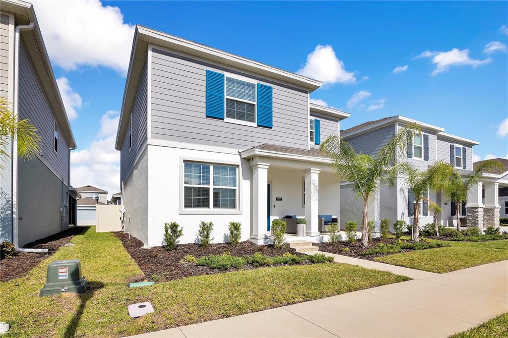 A two-story house with gray siding, white stucco, and blue shutters under a blue sky — 2865 FITNESS ST, CLERMONT, FL