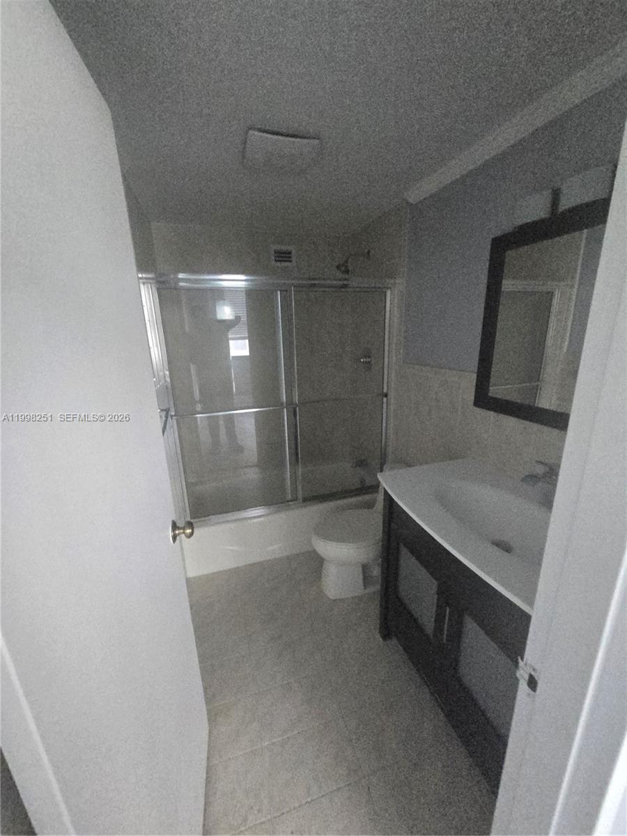 A bathroom features a vanity with a dark cabinet, a toilet, and a shower-tub combination — 825 Brickell Bay Dr # 750, Miami FL 33131, MIAMI, FL
