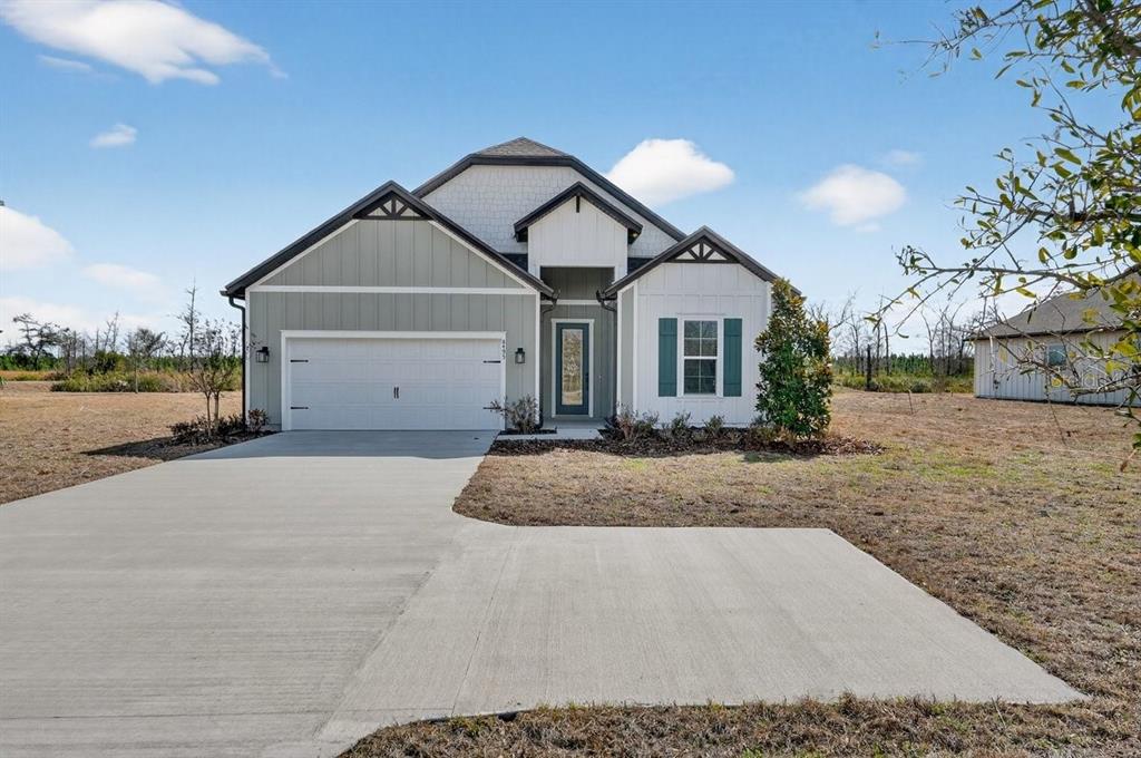 A single-story house with a white garage, gray siding, and a front concrete driveway — 8495 FORD ROAD, BRYCEVILLE, FL