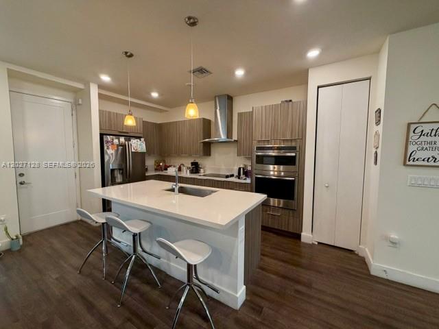 A modern kitchen features a white island, stainless steel appliances, and wood-toned cabinetry — DORAL, FL