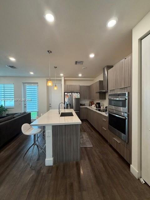 A modern kitchen features wood-grain cabinetry, a white quartz island, and stainless steel appliances — DORAL, FL