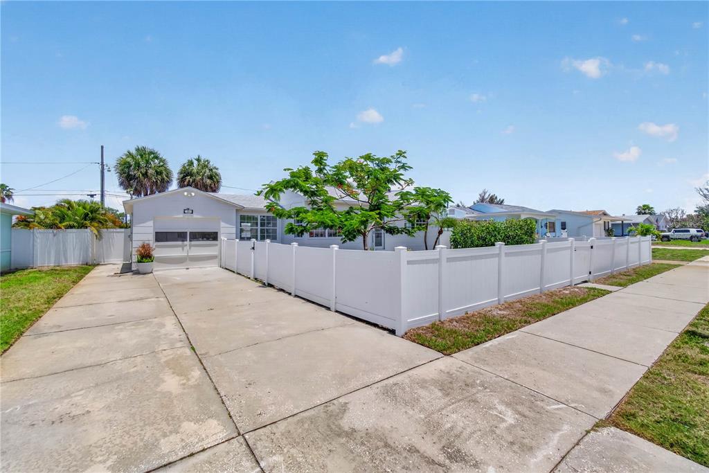 A white single-story house with a concrete driveway and a white vinyl privacy fence — 260 42ND AVENUE, ST PETE BEACH, FL
