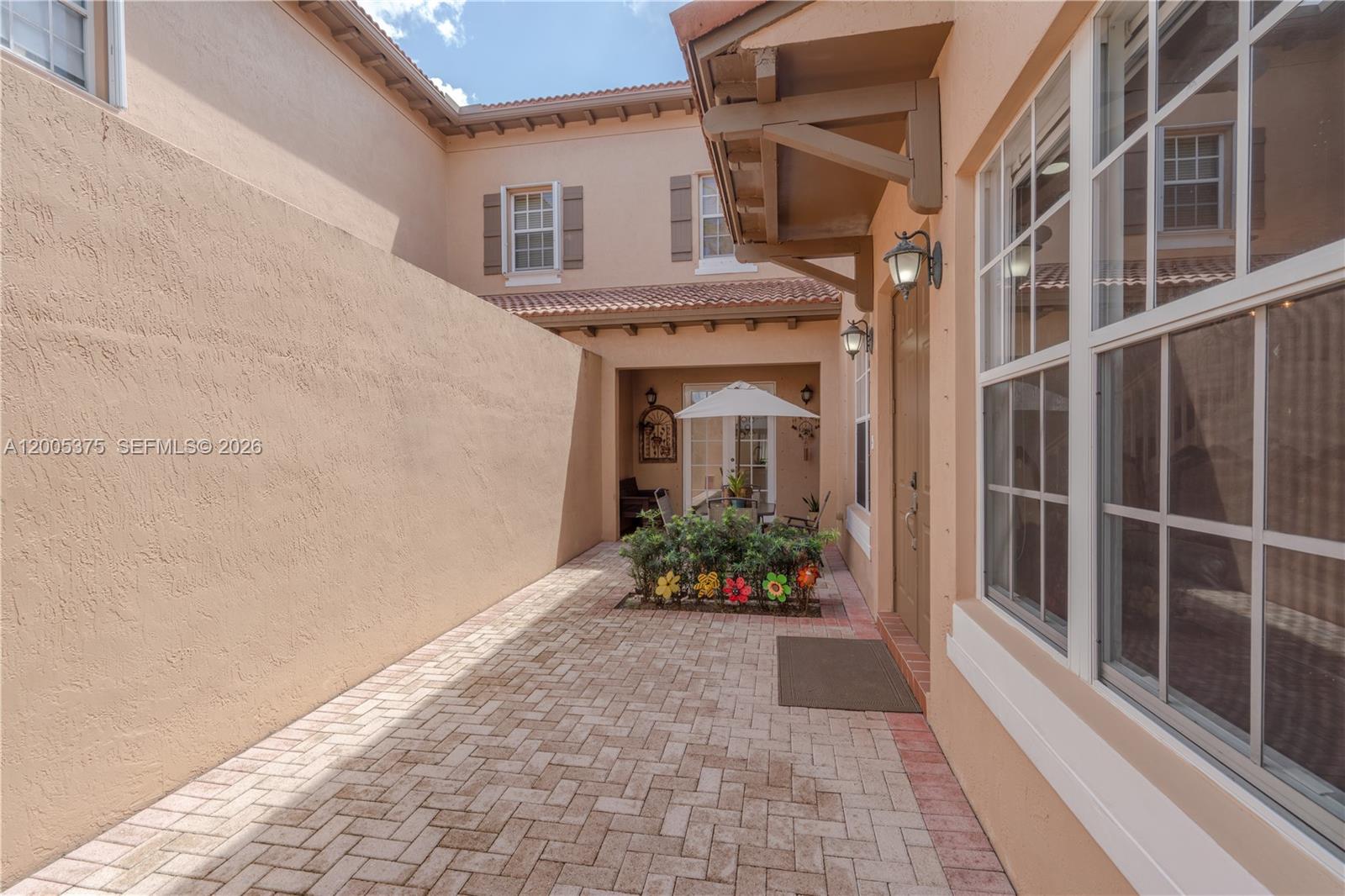 This virtually staged open-concept living and dining area features a staircase, wood flooring, and modern lighting — 623 SW 146th Ter, Pembroke Pines FL 33027, PEMBROKE PINES, FL