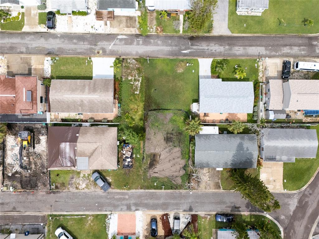 Aerial view of a residential neighborhood featuring several houses and a vacant lot — 18005 1ST STREET E, ST PETERSBURG, FL