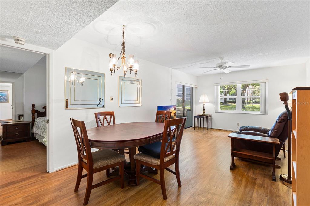 A dining area with a wooden table and chairs, adjacent to a living space — 2587 COUNTRYSIDE BOULEVARD UNIT 6110, CLEARWATER, FL