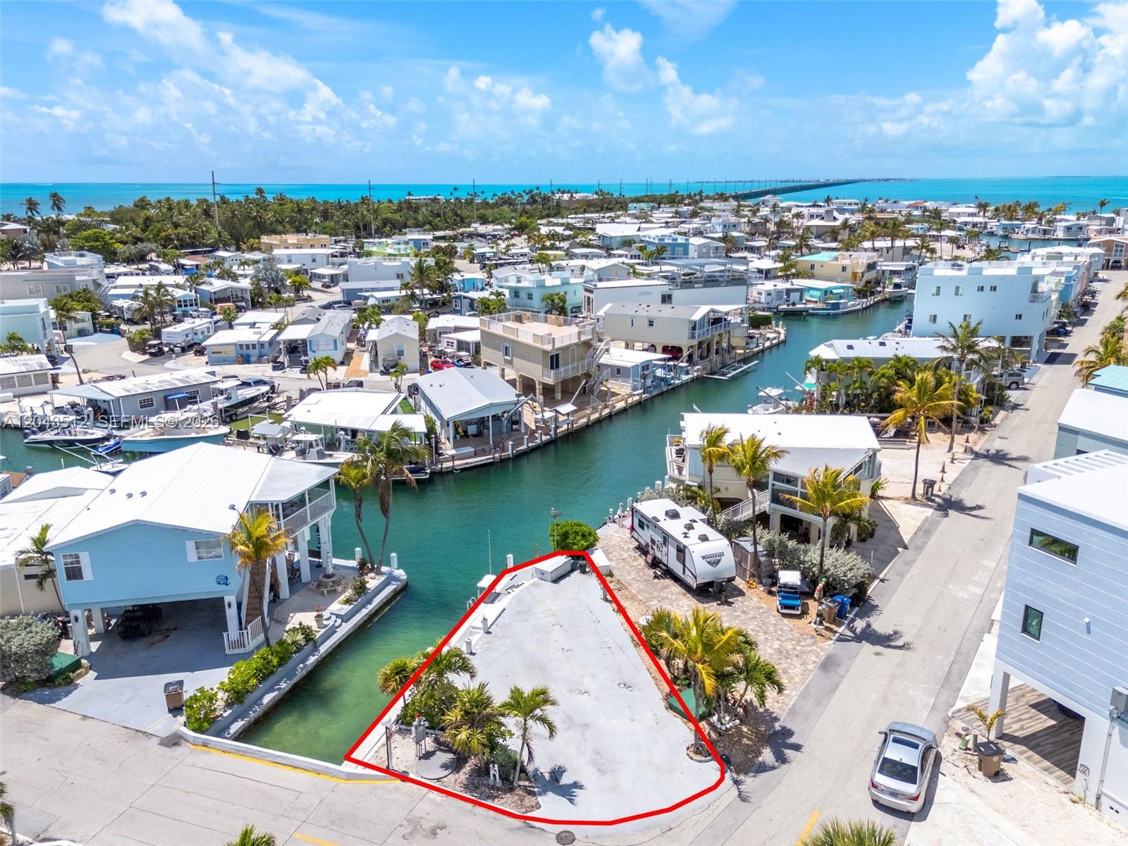 An aerial view shows a triangular waterfront lot with a concrete pad and palm trees — 65821 Overseas Hwy #291, Long Key FL 33001, LONG KEY, FL