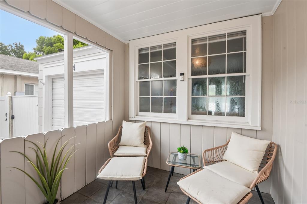 A screened-in porch features two wicker lounge chairs, a small side table, and windows — 624 KERNEYWOOD STREET, LAKELAND, FL