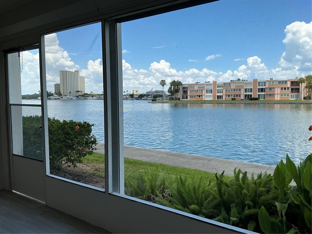 A view of a waterfront canal and apartment buildings from a screened-in porch — 7645 SUN ISLAND DRIVE S UNIT 101, SOUTH PASADENA, FL