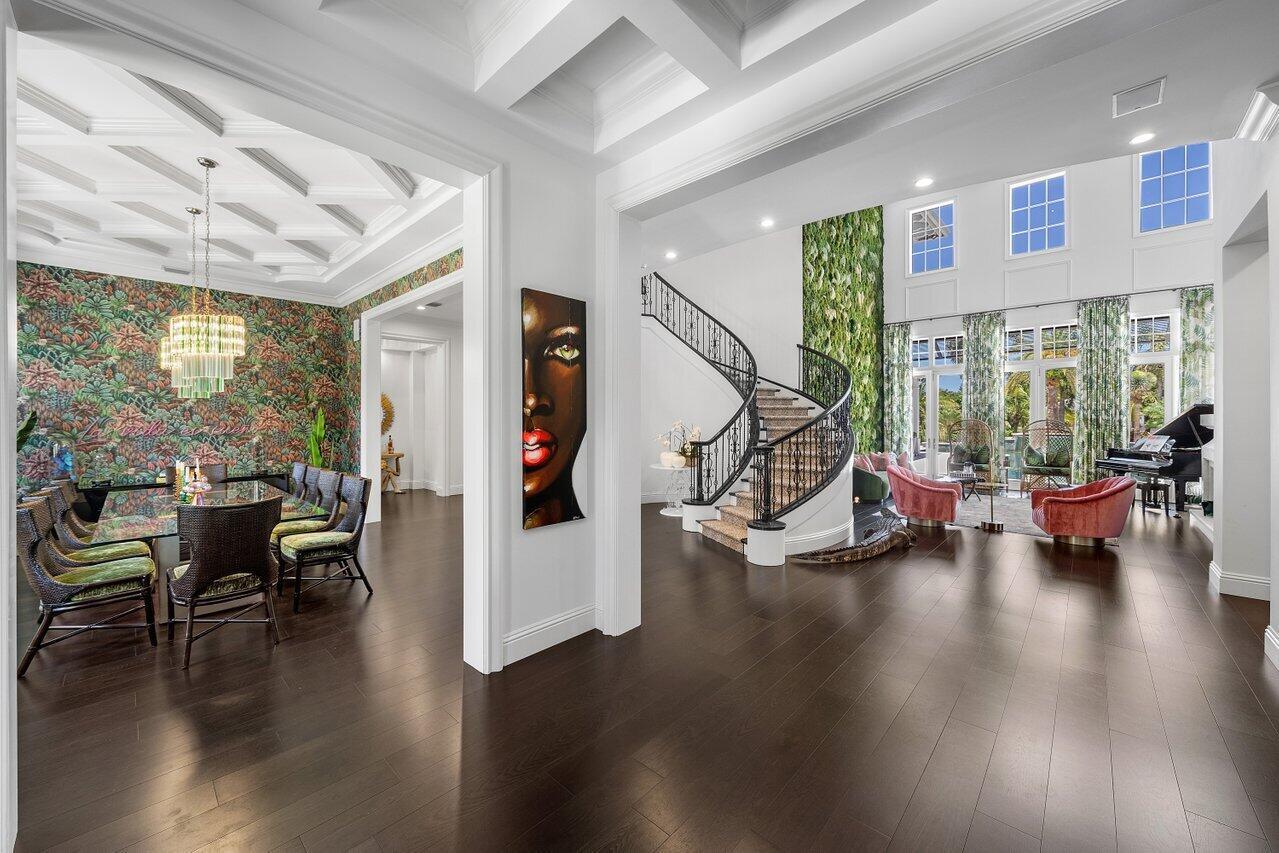 A grand foyer features a curved staircase, a living wall, and an adjacent dining room — 17837 Fieldbrook Circle W, Boca Raton FL 33496, BOCA RATON, FL