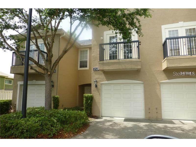 A tan multi-story townhouse exterior features two garage doors and two upper-level balconies — 2530 LANCIEN COURT UNIT 2, ORLANDO, FL