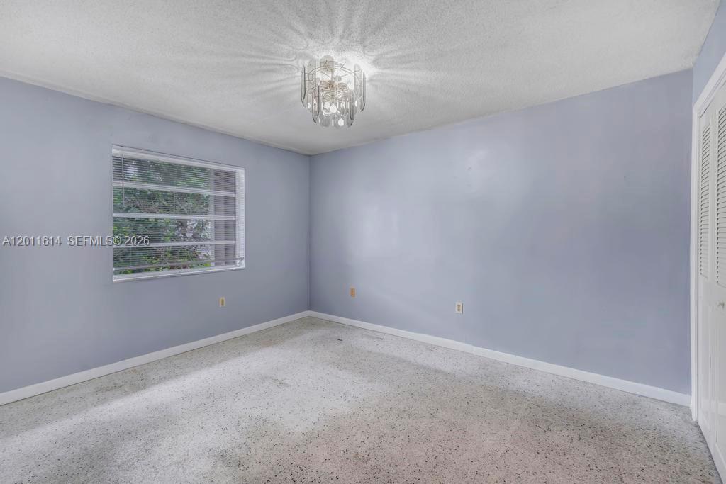 An empty bedroom features light blue walls, a white ceiling fan, and beige carpeting — 519 NW 10th Ave, Miami FL 33136, MIAMI, FL