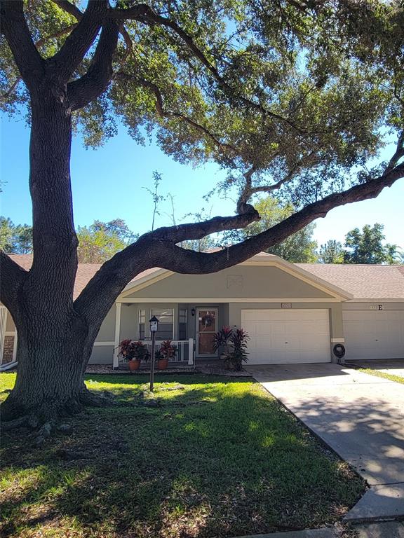 A large oak tree stands in the front yard of a single-story house with a garage — 9331 SW 84TH TERRACE UNIT D, OCALA, FL