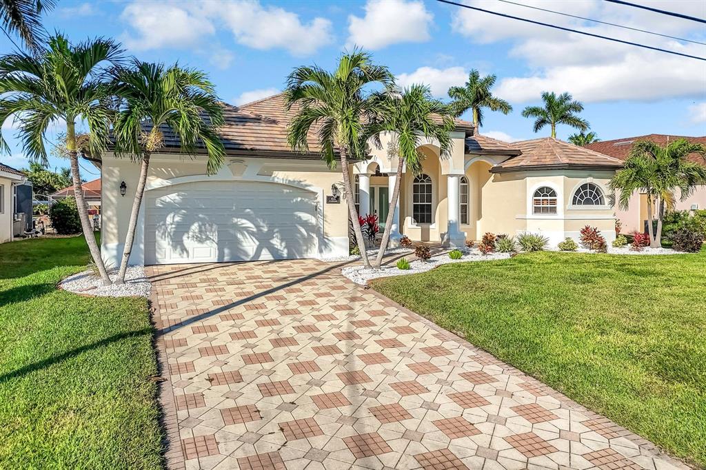 A single-story house with a paved driveway, palm trees, and a two-car garage — 4518 SW 22ND PLACE, CAPE CORAL, FL