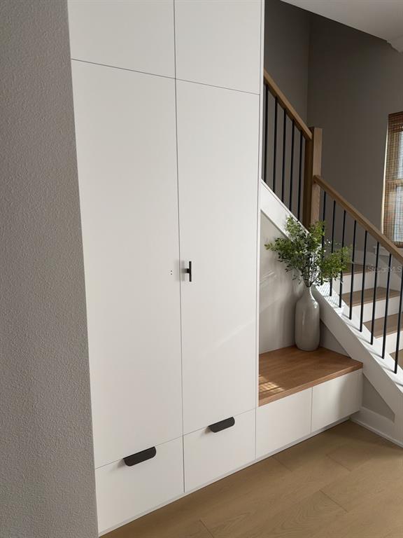 A white floor-to-ceiling cabinet with a built-in wooden bench sits beside a staircase — 6705 S HIMES AVENUE, TAMPA, FL