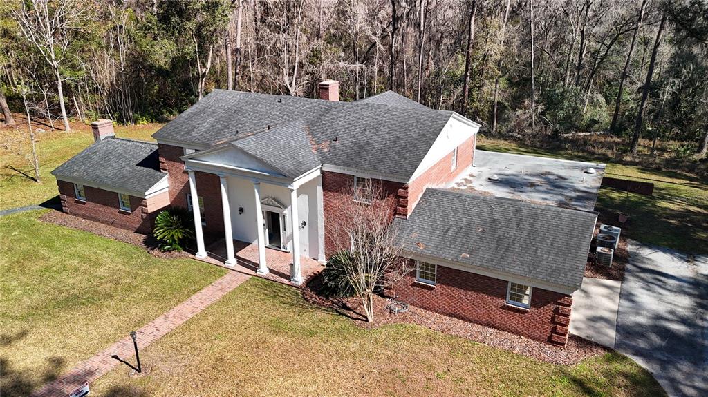 An aerial view of a two-story brick house with a white columned front porch — 1701 NW 30TH TERRACE, GAINESVILLE, FL