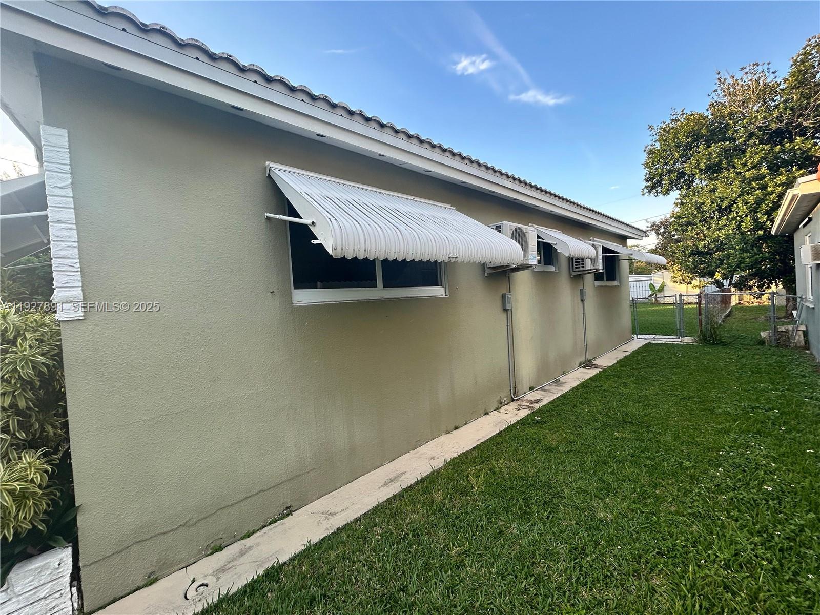 A single-story house with a green exterior, white awnings, and a front porch — 1915 Mayo St, Hollywood FL 33020, HOLLYWOOD, FL