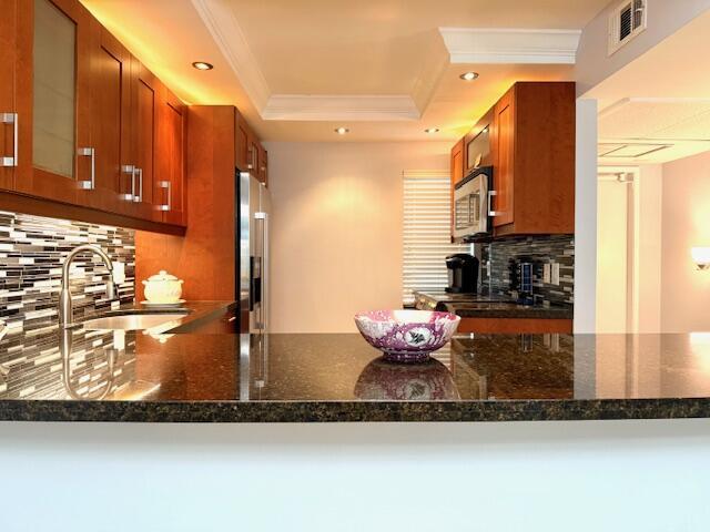 A kitchen with cherry wood cabinets, black granite countertops, and stainless steel appliances — 3080 N Course Drive # 202, Pompano Beach FL 33069, POMPANO BEACH, FL