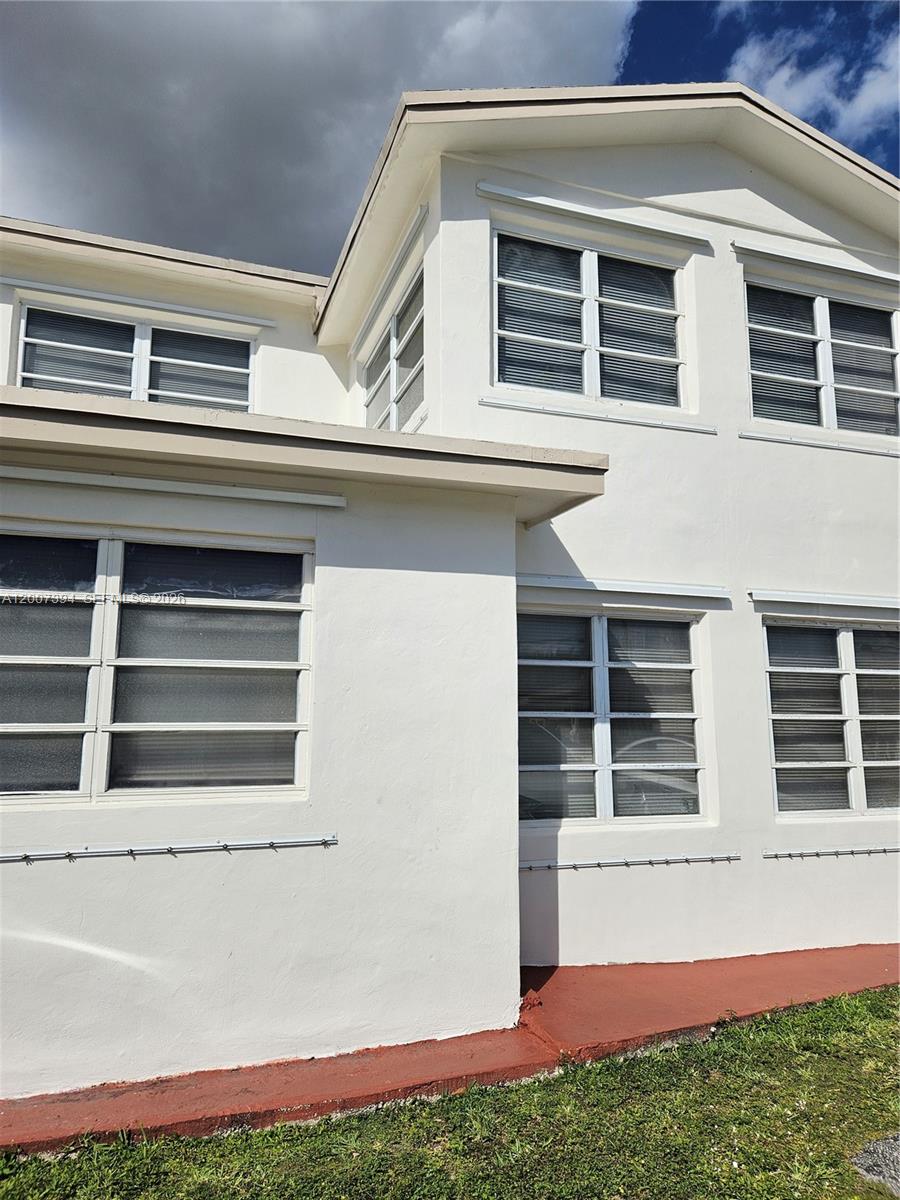 The exterior of a two-story white stucco building features multiple horizontal sliding windows — 3431-3433 SW 4th St, Miami FL 33135, MIAMI, FL