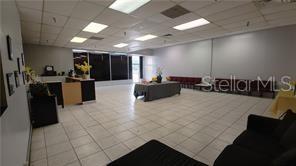 An open commercial space with white tile floors, a reception desk, and a central table — 2921 S ORLANDO DRIVE UNIT 178, SANFORD, FL