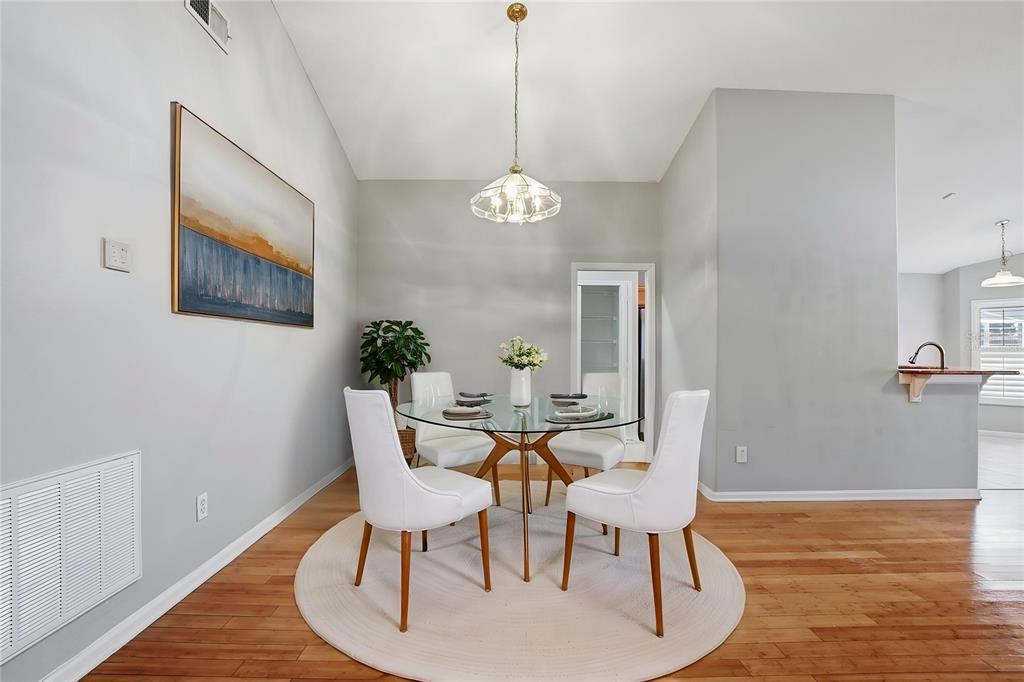 A dining area features a glass-topped table, four white chairs, and a round area rug — 15833 BAY VISTA DRIVE, CLERMONT, FL