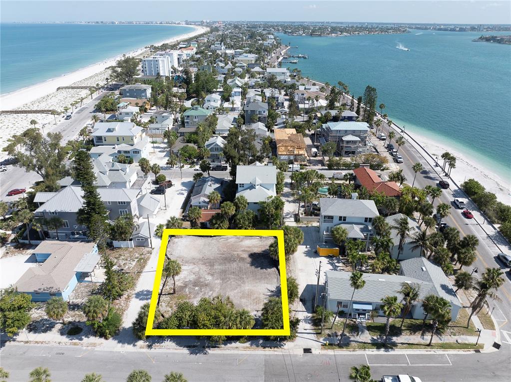 An aerial view shows a vacant, rectangular lot highlighted in yellow within a coastal neighborhood — 103 & 105 1ST AVENUE, ST PETE BEACH, FL