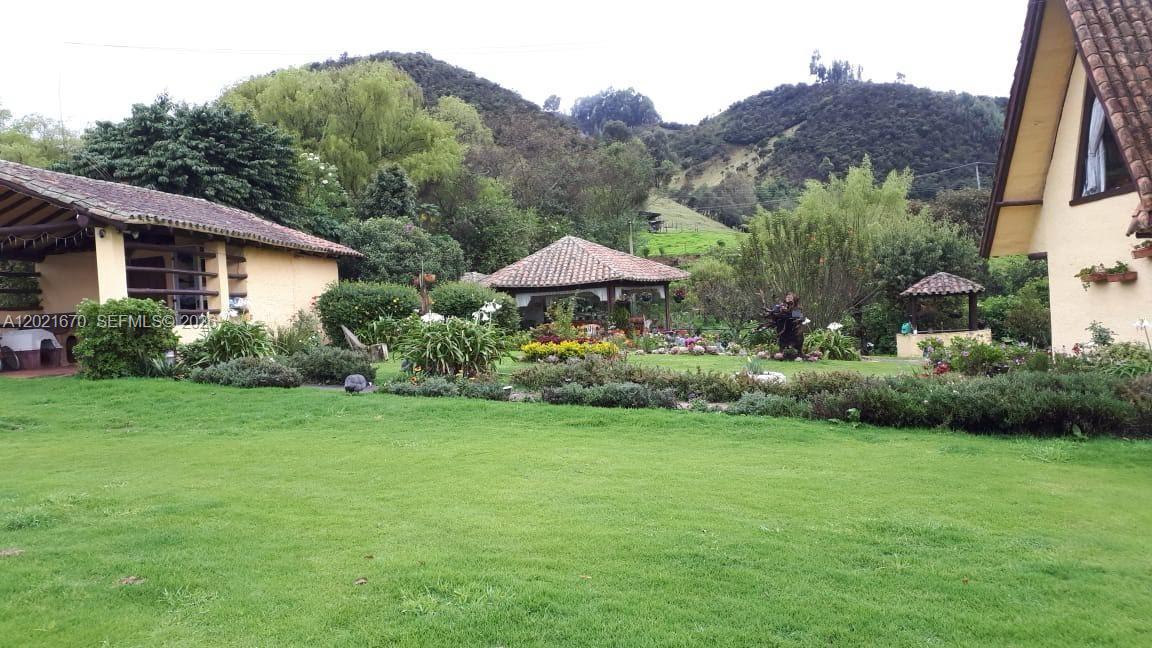 A grassy lawn sits in front of two houses and a gazebo near mountains — Subachoque Cundinamarca Colombia, 250220, FL