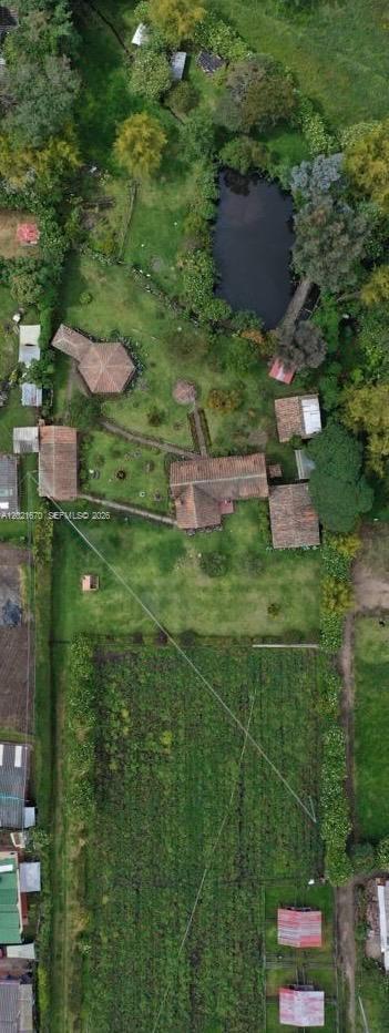 An aerial view shows a rural property with multiple buildings, a pond, and garden plots — Subachoque Cundinamarca Colombia, 250220, FL