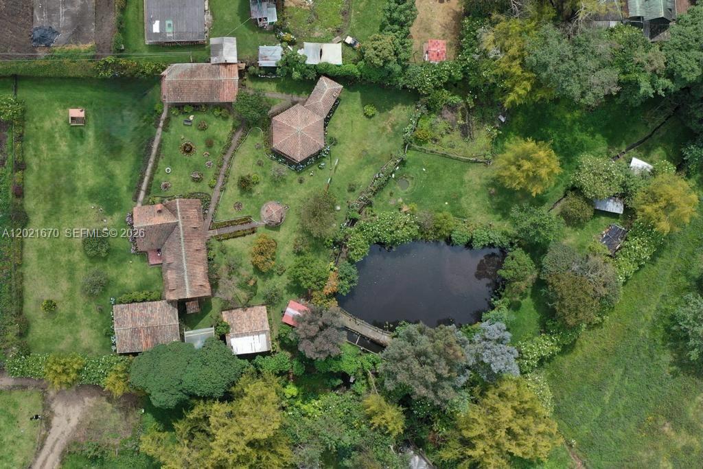 An aerial view shows a rural property with multiple buildings, a pond, and gardens — Subachoque Cundinamarca Colombia, 250220, FL