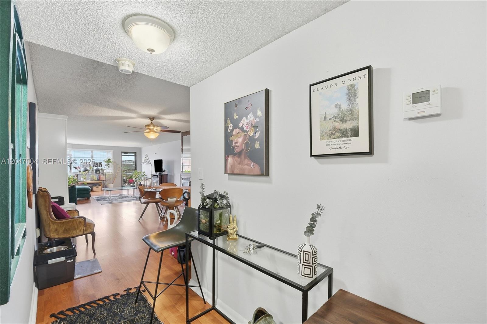 An entryway with a glass console table leads into an open-concept living and dining area — 20840 San Simeon Way # 609, Miami FL 33179, MIAMI, FL