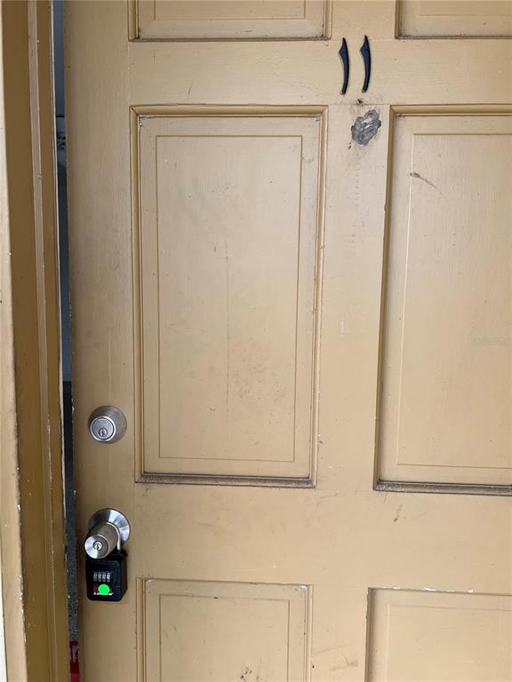 A tan-colored door labeled with the number 11 features a deadbolt and a lockbox — 305 E DAKIN AVENUE UNIT 11, KISSIMMEE, FL