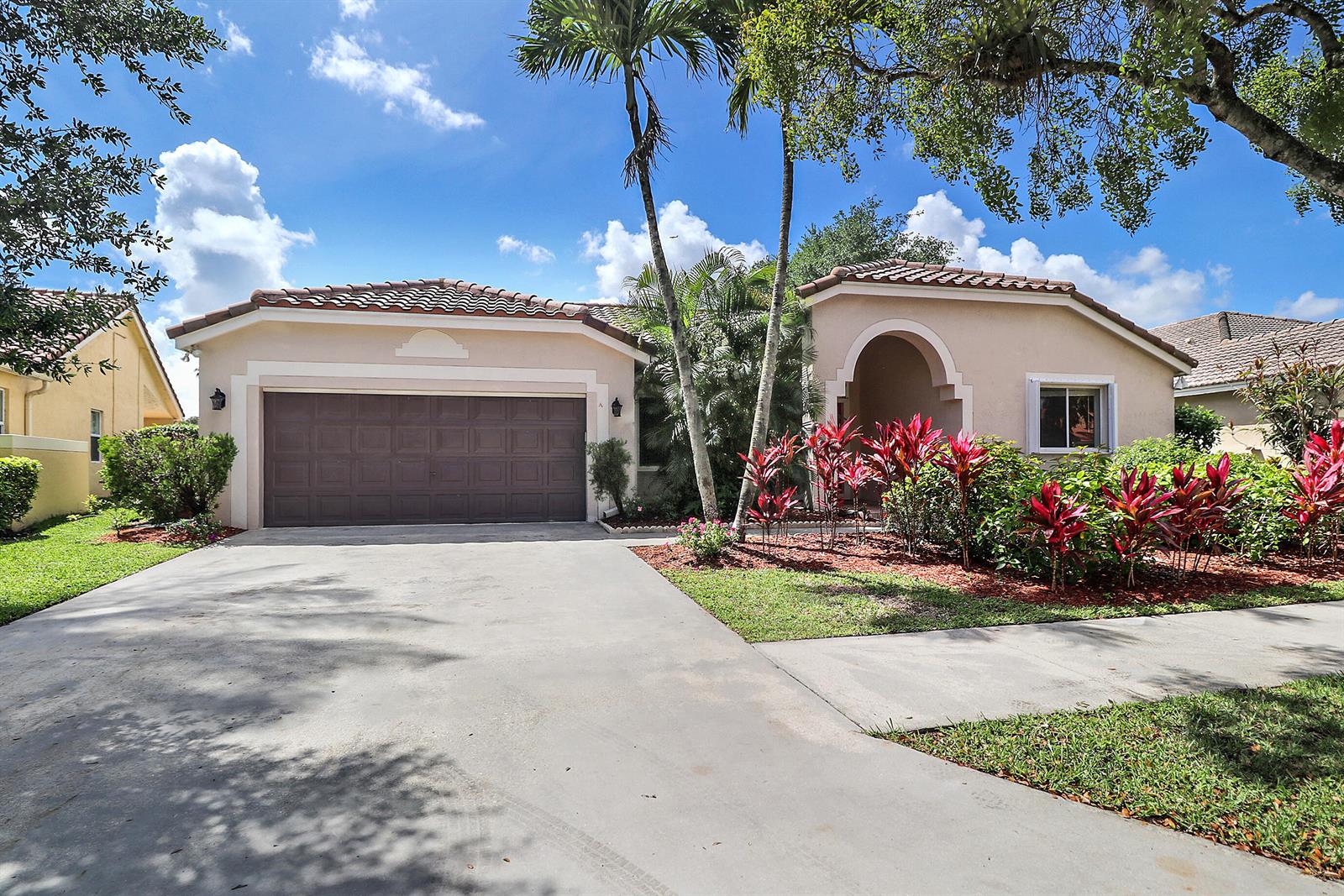 A single-story house with a two-car garage, arched entryway, and tropical landscaping — 1968 Water Ridge Drive, Weston FL 33326, WESTON, FL