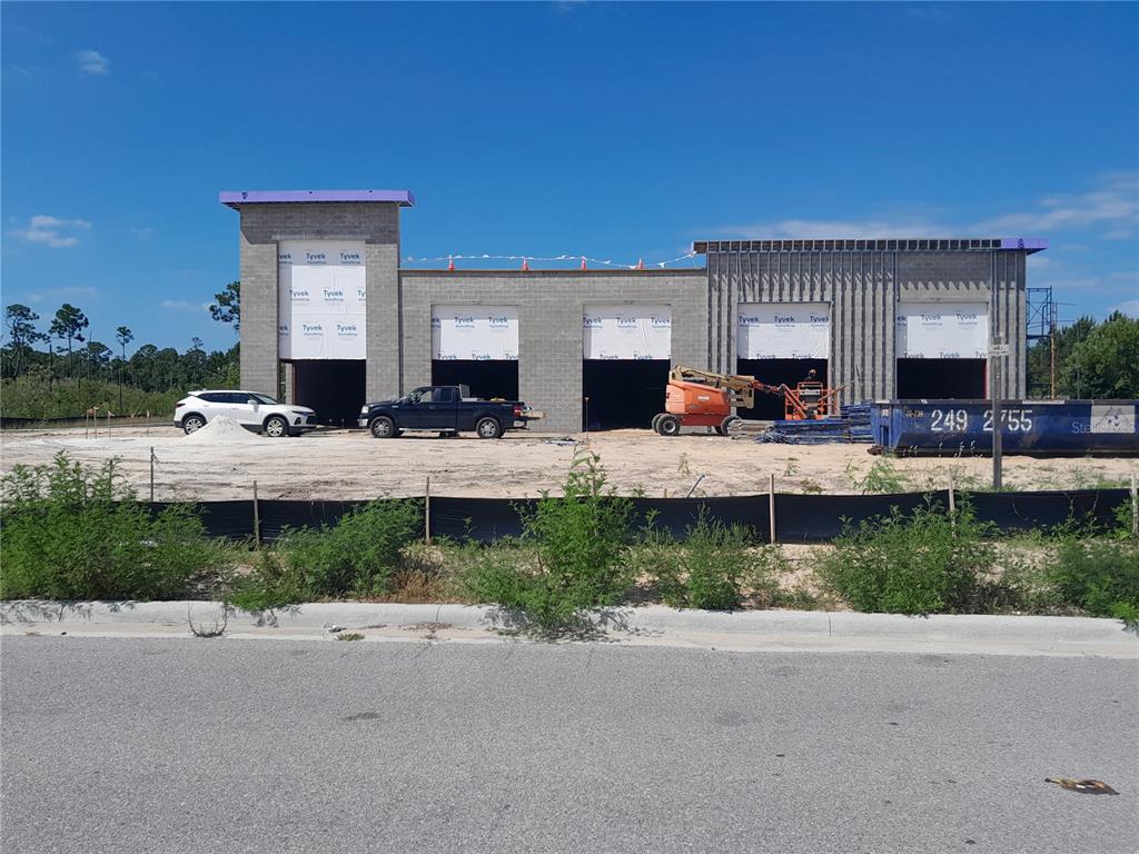 A construction site shows a partially built commercial building with five garage bays — 11697 PANAMA CITY BEACH PARKWAY, PANAMA CITY BEACH, FL