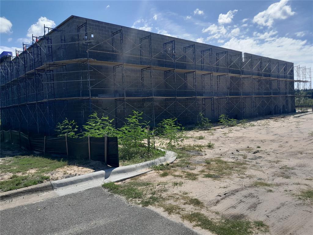 A multi-story commercial building under construction features concrete block walls and extensive exterior scaffolding — 11697 PANAMA CITY BEACH PARKWAY, PANAMA CITY BEACH, FL
