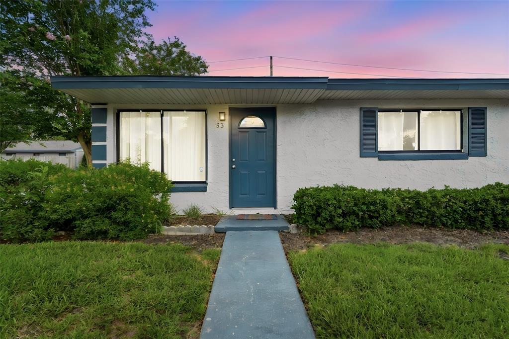 A single-story house with a blue front door, white stucco walls, and a concrete walkway — 605 NORTHLAKE BOULEVARD UNIT 33, ALTAMONTE SPRINGS, FL