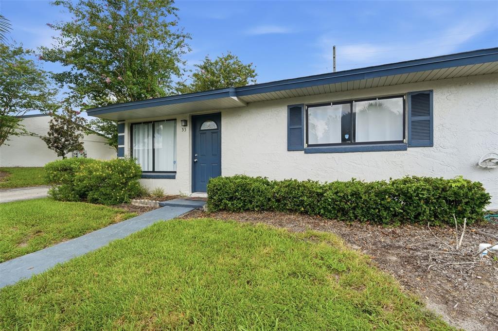 A single-story house with a blue door, white stucco walls, and a green lawn — 605 NORTHLAKE BOULEVARD UNIT 33, ALTAMONTE SPRINGS, FL
