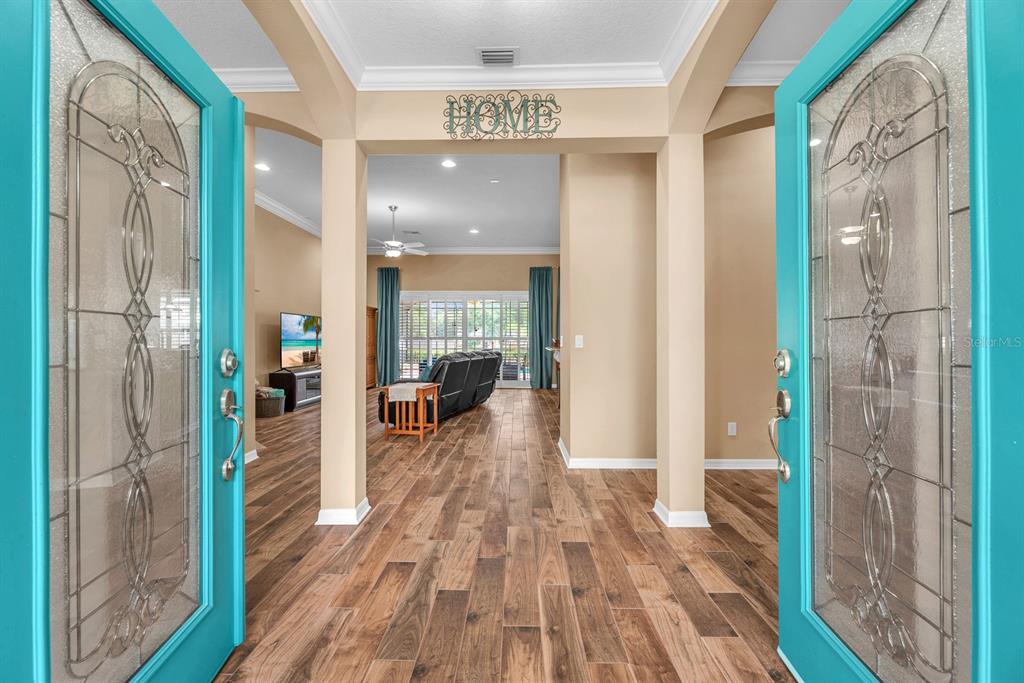 A view through an open turquoise double door into a home with wood-look flooring — 2817 DURANT TRAILS BOULEVARD, DOVER, FL