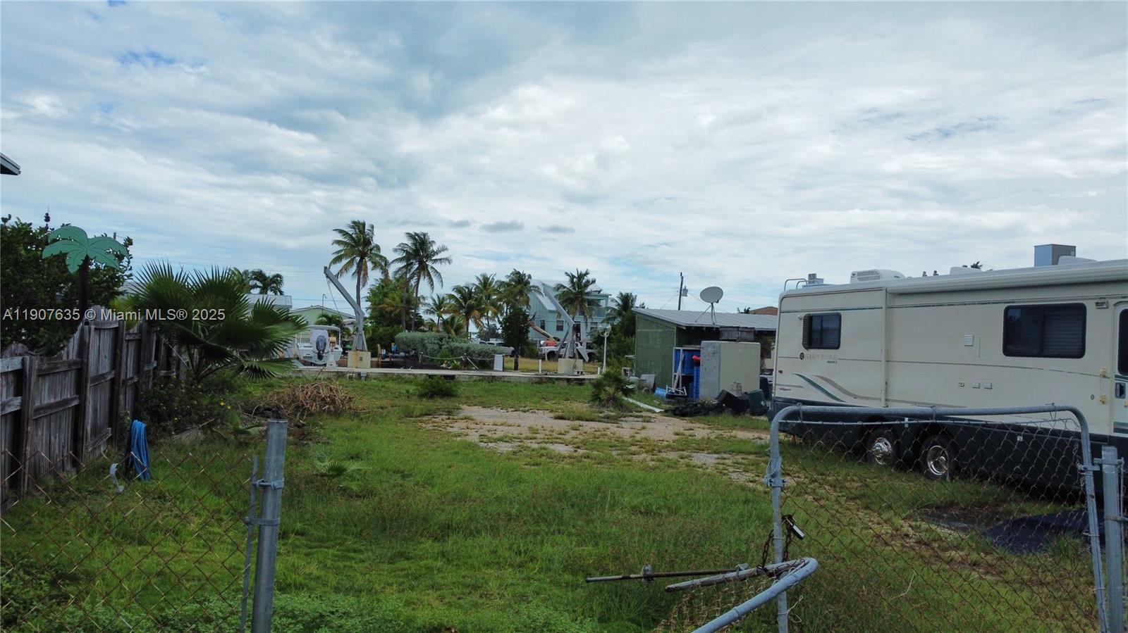 An outdoor lot features a grassy area, a parked recreational vehicle, and palm trees — 93 N Conch Ave, Marathon FL 33050, MARATHON, FL
